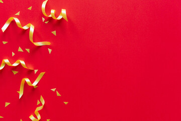 close up on group of gold color of rolling ribbon and confetti on red background with copy space for happy Chinese new year ,festival ,birthday and anniversary, concept design