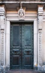 Vintage iron door with a handle in the shape of a lion's head. Architectural element of the Stieglitz State Academy, St. Petersburg, Russia.