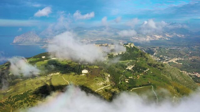 Aerial view high above clouds, revealing the Erice city, in Sicily, Italy - circling, drone shot