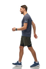 fitness, sport and healthy lifestyle concept - smiling man in sports clothes with smart watch or...