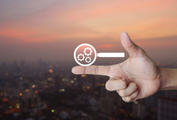 seo flat icon on finger over blur of cityscape on warm light sundown, Technology search engine...