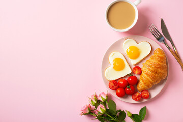 Healthy breakfast with eggs hearts and cup of coffee on pink background