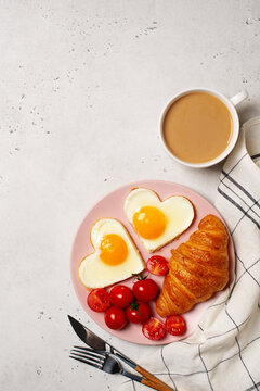 Healthy breakfast with eggs hearts and cup of coffee on grey background