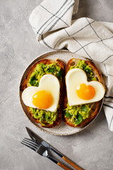 Healthy breakfast with eggs hearts and cup of coffee on grey background