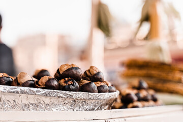 Roasted chestnuts on pan. Grilled chestnut snack food on the street market