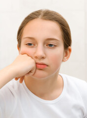the face of a teenage girl, she looks at herself in the mirror and touches her face with her hand, good and clean skin is a concept of beauty and health