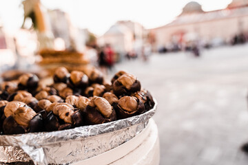 Roasted chestnuts on pan. Grilled chestnut snack food on the street market