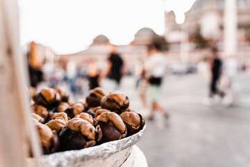 Roasted chestnuts on pan. Grilled chestnut snack food on the street market