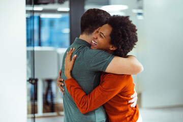Happy african-american woman, giving her business partner a hug.