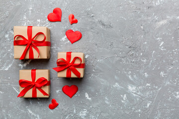 Valentine day composition: red gift box with bow and heart. Christmas present. View from above. Space for text. Holday greeting card