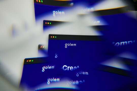 Milan, Italy - January 11, 2022: golem - GLM logo on laptop screen seen through an optical prism. Dynamic and unique image form golem, GLM coin website. Illustrative editorial.