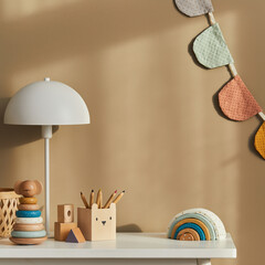 Interior design of stylish kid room space with white shelf, wooden toys, child accessories, white...