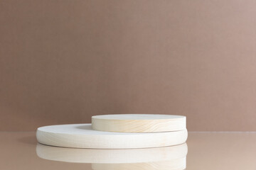 Cylindrical wooden scenes on a beige table on a brown background. Premium podium for advertising your product. Background for the product presentation.