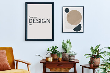 Domestic interior of living room with vintage retro shelf, a lot of house plants, cacti, wooden mock up poster frame on the white wall and elegant accessories at stylish home garden. Template.
