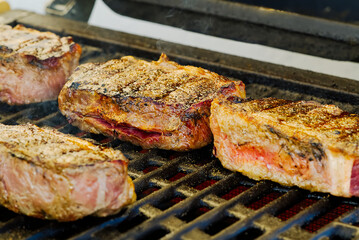 grilling steaks on gas grill and shot with selective focus.
