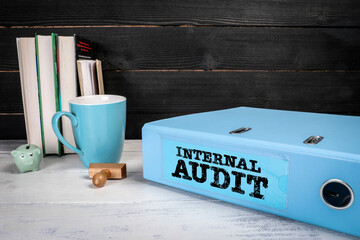 Internal Audit. Blue office document binder on a wooden table