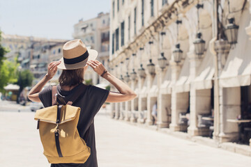 Travel concept, beautiful tourist woman walking in Kerkyra old town during vacation, cheerful student girl traveling abroad in summer, Corfu island, Greece  - obrazy, fototapety, plakaty