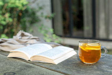 An open book and a cup of tea on the table.