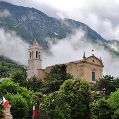Close Up of Old Stone Church seen against Wooded Hillside  with Low Clouds