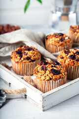 Fresh homemade oatmeal muffins with dried cranberry on white wooden tray. Healthy gluten free dessert. Close-up.