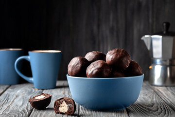 Dark chocolate balls stuffed with marshmallows on wooden background