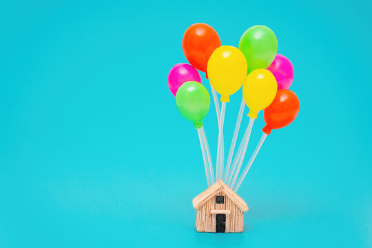 Tiny wooden house with multicolored balloons
