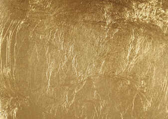 Closeup shot of abstract golden background. Gold painted stone wall texture.