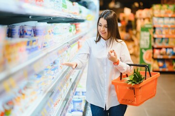 Woman grocery shopping and looking very happy
