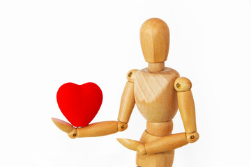 yellow wooden mannequin holding a red heart