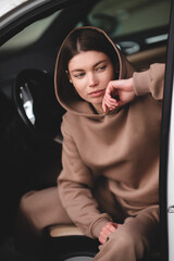Attractive young girl driving a car. The girl gets out of the car