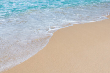 Fototapeta na wymiar Soft ocean wave on clean sandy beach background