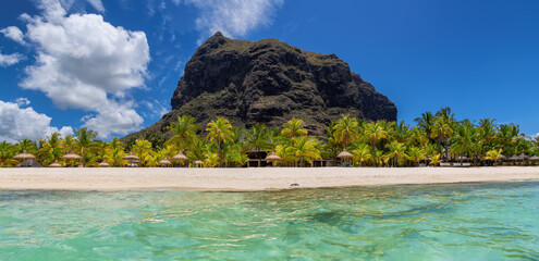 Beautiful Le Morne beach with palm trees and mountains from tropical sea in Mauritius island.