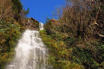 Fototapeta premium Stunning Devil's chimney waterfall and in county Sligo, Ireland. Irish landscape and landmark. Blue cloudy sky. Beautiful nature scene.