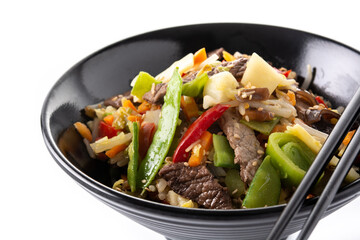 Beef, vegetables and sesame seeds in black bowl isolated on white background. 	