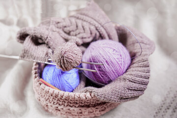 Fototapeta na wymiar Skeins of wool yarn and knitting needle in basket. Concept of knitting, needlework, hobby