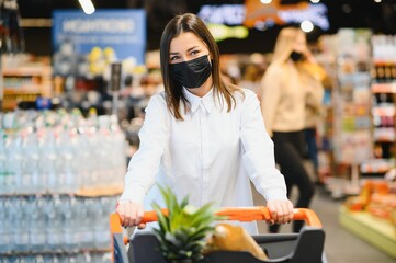 Young woman with face mask walking through grocery store during COVID-19 pandemic.
