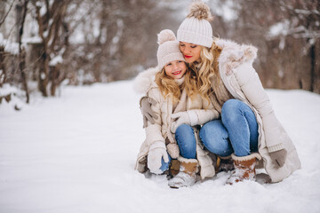 Fototapeta premium Mother with daughter walking together in a winter park