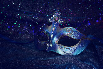 Photo of elegant and delicate Venetian mask over blue dark silk background - obrazy, fototapety, plakaty
