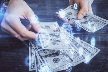 Multi exposure of technology drawing hologram and us dollars bills and man hands. Data concept