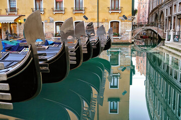 Fototapeta na wymiar Detail on the steel bow of Venetian gondolas moored in Venice, Italy.