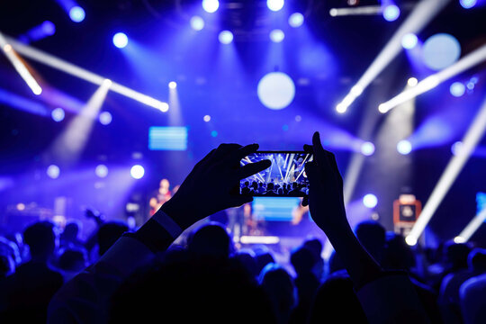 Making video recordings and pics on a smartphone at the concert or light show for publishing on social media.