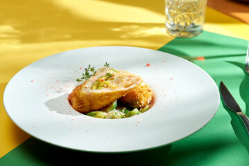 Chicken Kiev cutlet with Brussels sprouts in a white plate. Colored backgrounds. Hard light. selective focus