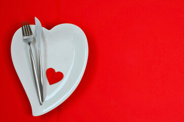 valentines day table setting flat lay with love white ceramic plate shape heart, festive decoration, fork and knife
