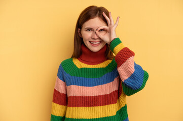 Young English woman isolated on yellow background excited keeping ok gesture on eye.