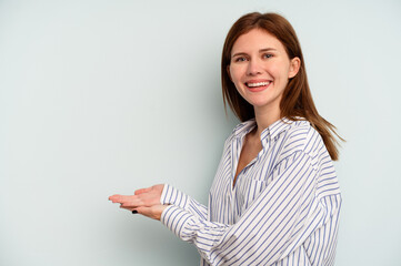 Young English woman isolated on blue background holding a copy space on a palm.