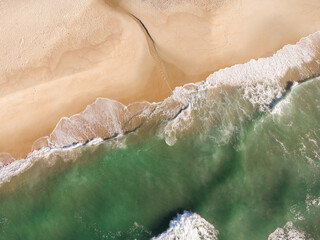 Fototapeta na wymiar Aerial view of Prainha Beach, a paradise in the west side of Rio de Janeiro, Brazil. Greenish sea waves and sand. Top view. Sunny day at dawn. Drone Photo