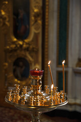 Altar and candles. Interior in the temple Orthodox Church. Christianity. Festive interior decoration with burning candles and icon. The ceremony of infant baptism. Baptismal font