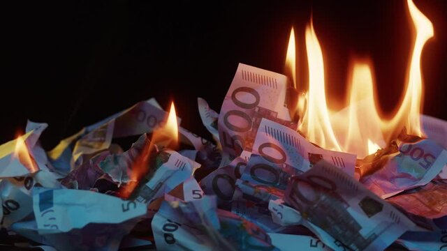 Burning of 500 euro banknotes close-up. Flame of fire from a pile of cash. Financial crisis and depressed economy. Paper money loss concept. 