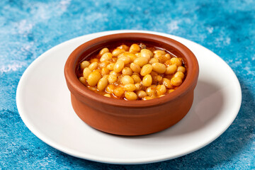 Hot turkish bean stew on blue background. Ispir beans cooked in a casserole - Kuru Fasulye