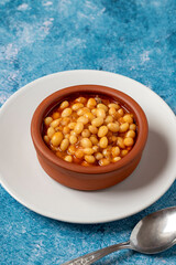 Hot turkish bean stew on blue background. Ispir beans cooked in a casserole - Kuru Fasulye